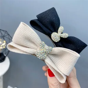 Closeup detail of cute rhinestone rabbit knitted bow hair clip, stylish winter design.