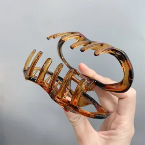 Large translucent acrylic hair claw clip, stylish tortoise shell design for women.