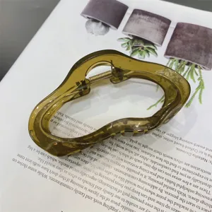 Close-up of olive green jelly acrylic hair claw clip with irregular cloud shape and spring.
