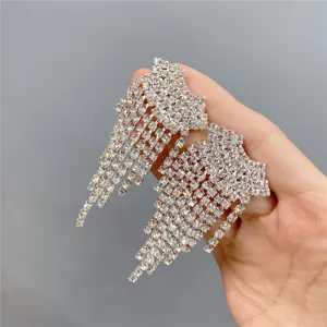 Close-up detail of sparkling crystal rhinestone fringe drop earrings, shining bright in hand.
