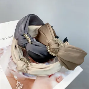 Elegant rhinestone knotted wide hair band for women, stylish satin headband accessory.