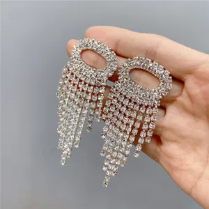 Close-up detail of luxury rhinestone fringe earrings, sparkling crystal tassel drop design.