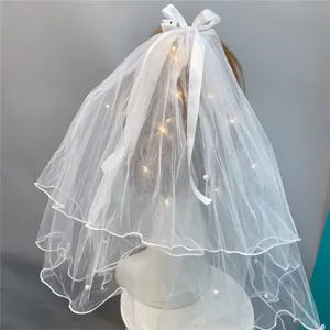 Detail view of white double layer flower girl veil with pearls and warm LED lights bow.