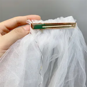 White tulle hair veil clip with gold metal alligator clip and delicate fairy lights.