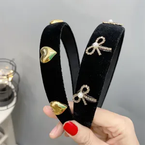 Black velvet sponge headband with metal hearts and rhinestone bow for elegant women daily.