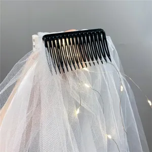 Detailed view of the bridal veil hair comb featuring LED fairy lights and white mesh design.