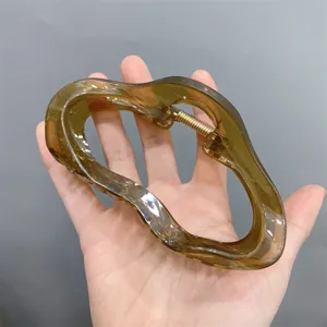 Detail view of the jelly brown acrylic cloud hair claw clip, stylish and transparent design.