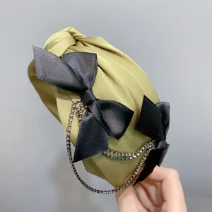Green headband with black satin bow and rhinestone tassel chain for sweet fashion styling