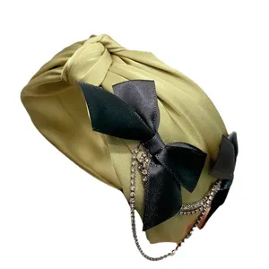 Sweet olive green knotted headband featuring black ribbon bow and sparkling rhinestone tassel.