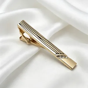 Élégante pince à cravate dorée pour homme avec rayures émaillées noires et strass.