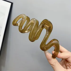 Detailed shot of a stylish translucent brown wavy hair claw clip, chic daily hair accessory.