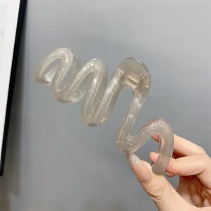 Translucent wavy hair claw clip, large jelly design with subtle glitter for elegant styling.