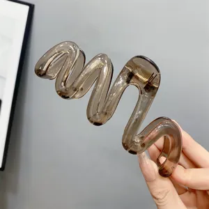 Detail view of the elegant translucent wave hair claw clip, showing unique jelly brown style.