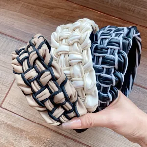 Vue détaillée de trois serre-tête élégants en cuir PU tressé en kaki, blanc et noir.