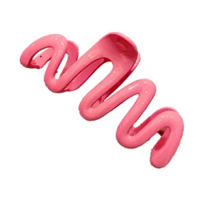 Close-up detail of the pink wavy jelly hair claw clip showing glossy finish and unique shape.