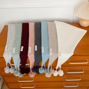 Vue detaillee de l'echarpe triangulaire tricotee d'hiver avec pompon, chale chaud pour femmes.
