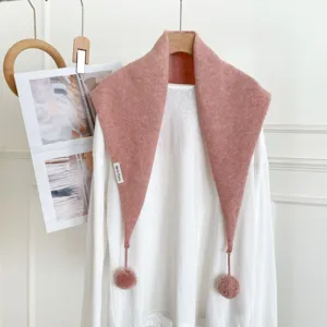 Détail d'écharpe triangulaire en tricot rose avec texture douce et pompons mignons.