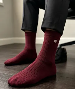Close-up detail of dark red ribbed merino wool crew socks worn by man, soft warm texture.