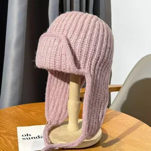 Pink knitted trapper hat with earflaps and straps, warm thick winter bomber hat for women.