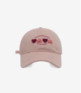 Sweet pink baseball cap with embroidered heart pattern and cute text, soft top and wide brim.
