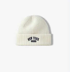 Primer plano de un gorro de punto acanalado blanco con detalle bordado de Nueva York.