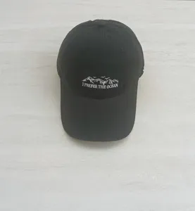 Detailed close-up of black baseball cap featuring front mountain embroidery and English text.