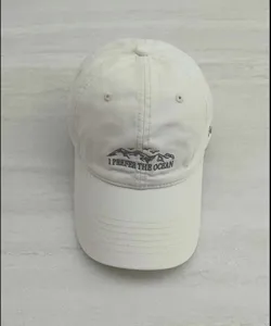 Detailed close-up of the beige embroidered baseball cap featuring ocean theme and cotton fabric.