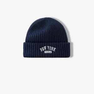 Primer plano del gorro de punto azul marino con bordado blanco de Nueva York USA.