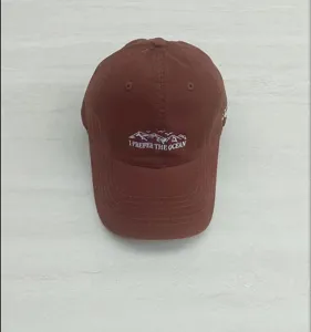 Brown embroidered baseball hat with mountain ocean graphic detail, casual streetwear cap.