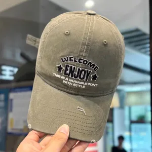 Vista de cerca de la gorra de béisbol lavada con bordados detallados y agujeros en la visera.