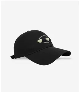 Close-up detail of black cotton baseball cap featuring cute heart embroidery and text.