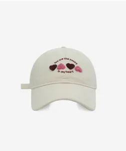 Close-up detail of the sweet embroidered heart baseball cap with cute poetry text design.