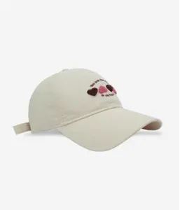 Beige baseball cap detail showing cute 3D heart embroidery and soft cotton fabric.