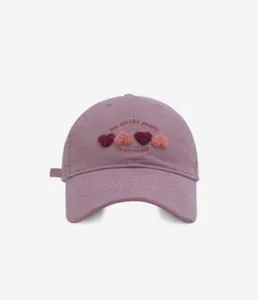 Detailed view of the sweet heart embroidered baseball cap featuring soft purple fabric.