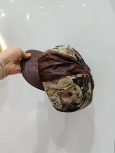 Primo piano dettagliato che mostra il tessuto jacquard con cani e la visiera in pelle.