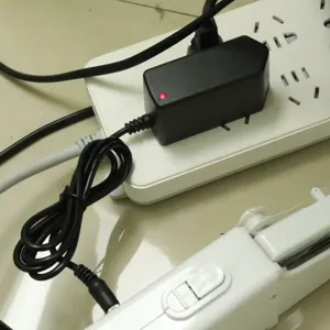 Vista detallada del adaptador de corriente negro de repuesto para la máquina de coser.