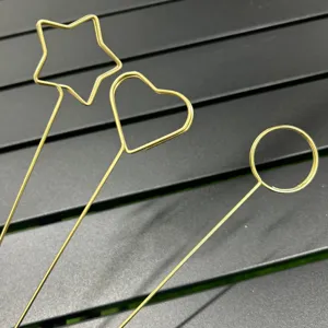 Gold metal wire card clips and floral picks featuring star, heart and round shapes for details.