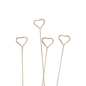 Close-up of golden metal wire heart-shaped floral picks and card holders for arrangement.