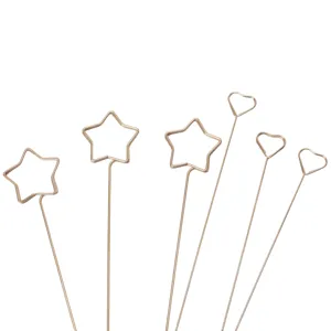 Detail view of metal wire card clips with star and heart shapes, rose gold finish.