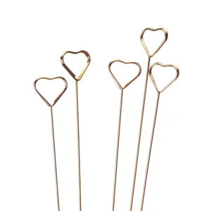 Close up of gold metal heart shaped card holders and floral picks for decoration and arrangement.