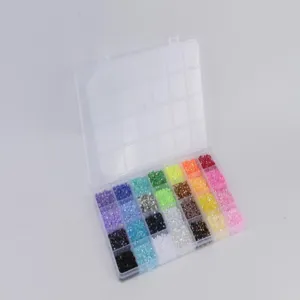Colorful flatback resin rhinestones in multi-grid storage box for nail art and DIY crafts.