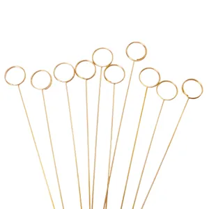 Close-up view of gold metal card holders, wire floral picks and memo clips for flowers.