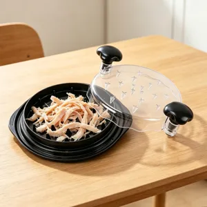Vista dettagliata del tritatutto manuale per pollo con coperchio trasparente e base nera con carne.