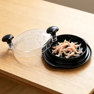 Primo piano dello strumento manuale per tritare la carne di pollo con coperchio trasparente.