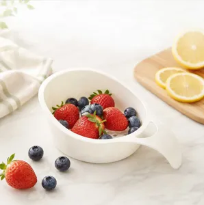 Detailed view of the white mini draining basket with fresh strawberries and blueberries.