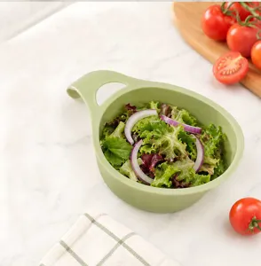 Green mini silicone drain basket with handle for kitchen fruit and vegetable washing detail.