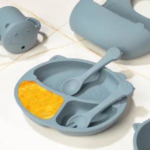 Detail shot of silicone baby feeding set with divided plate, spoon, fork, and cute cup.