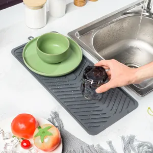 Silicone dish drying mat detail showing textured surface and drainage grooves by sink.