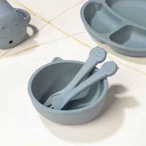 Grey silicone baby feeding set detail featuring cute cat bowl, spoon, fork and divided plate.
