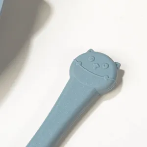 Silicone baby feeding spoon detail, cute blue cartoon handle for infant tableware set.